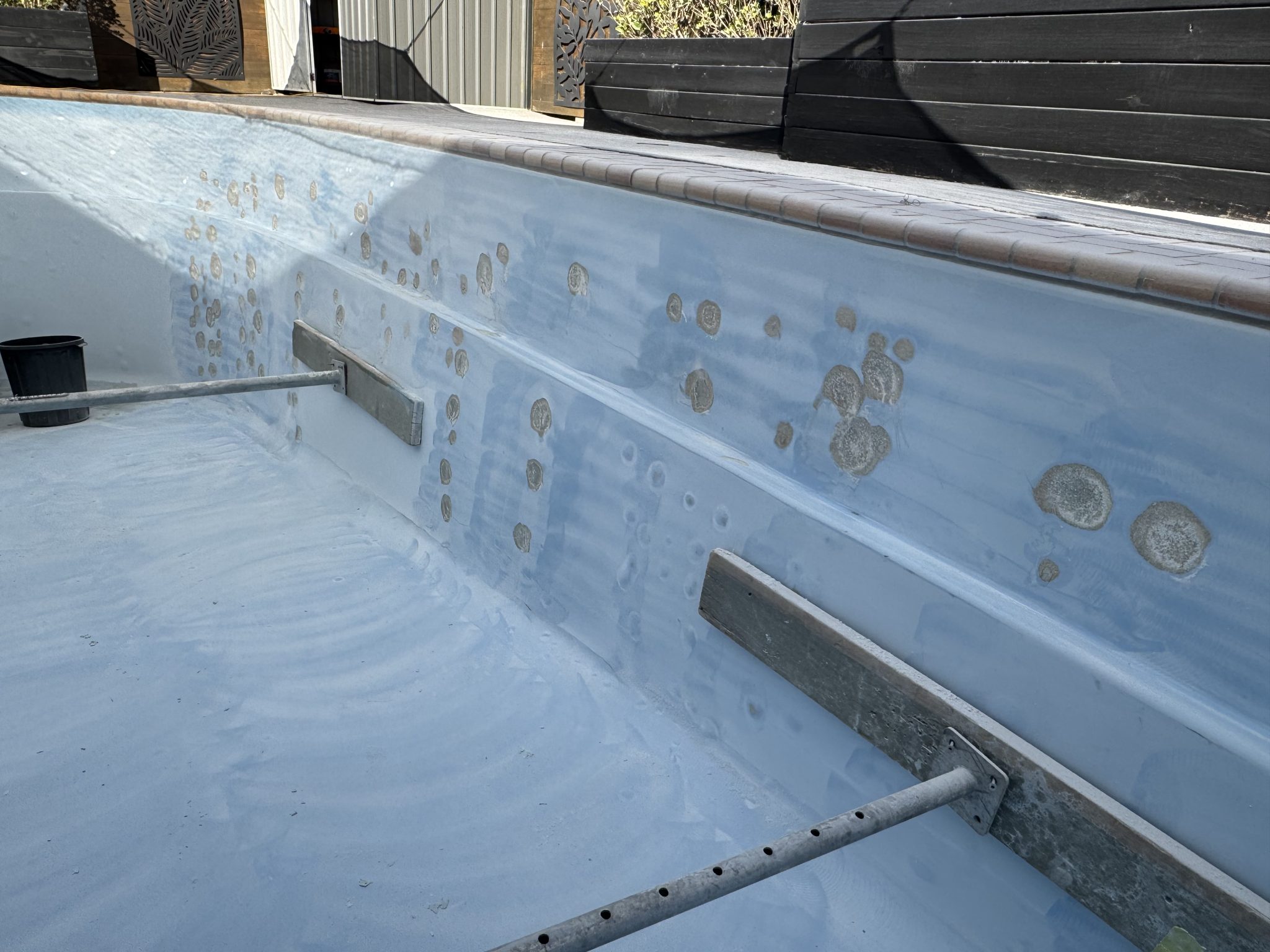 Tired fibreglass surface stripped back showing osmosis blisters