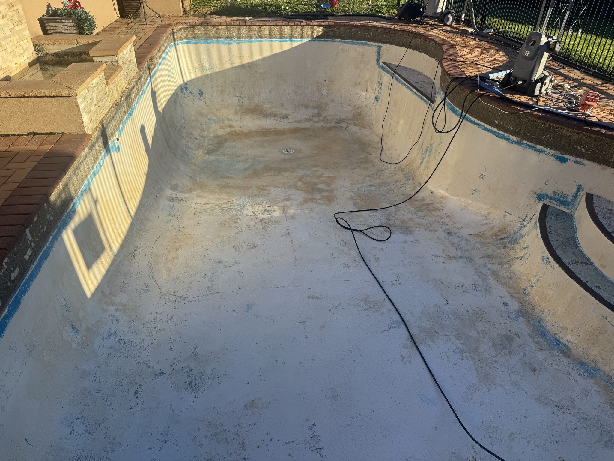 Old pool drained and stripped back before resurfacing