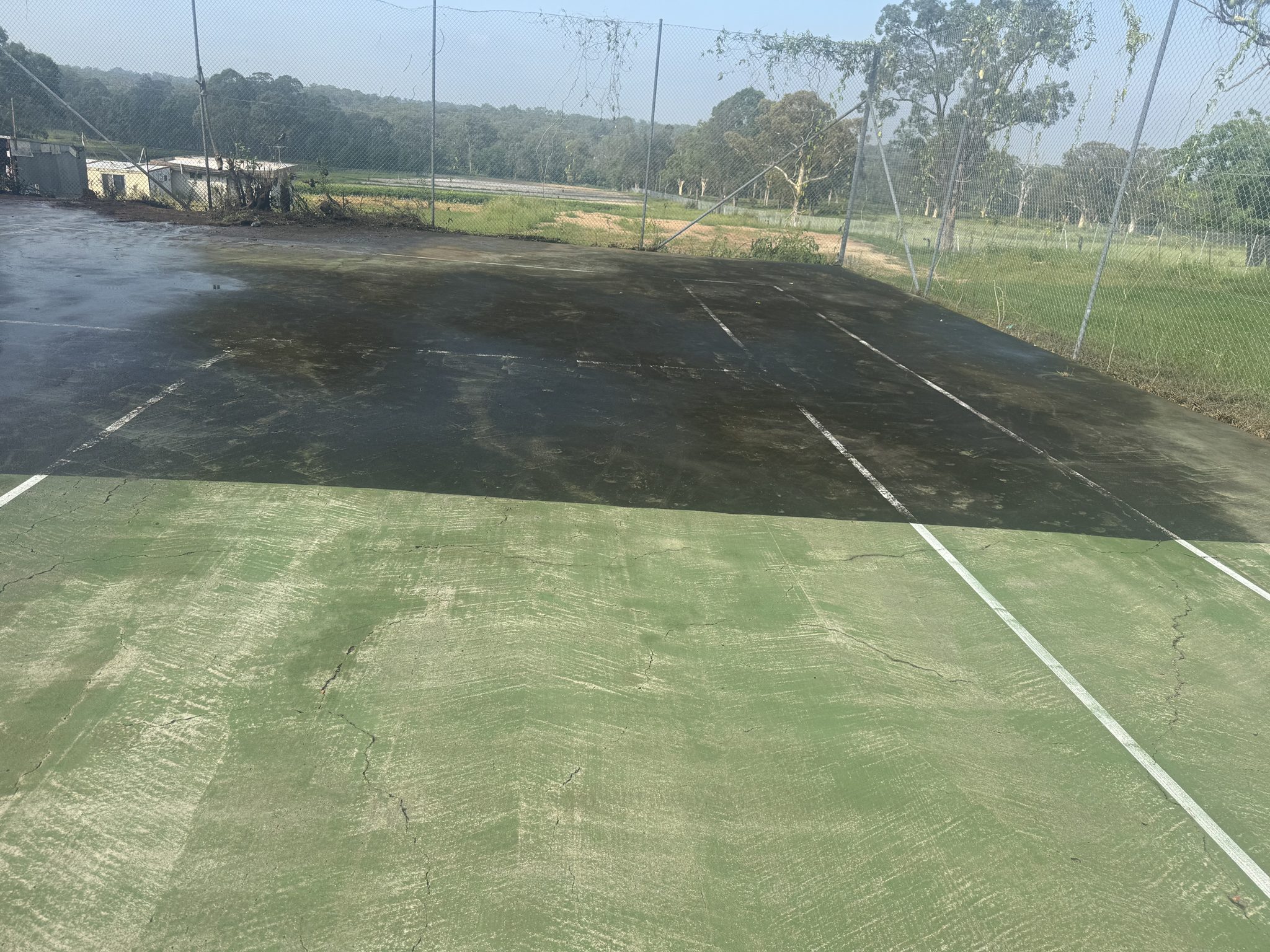 Freshly cleaned tennis court with crisp white lines restored