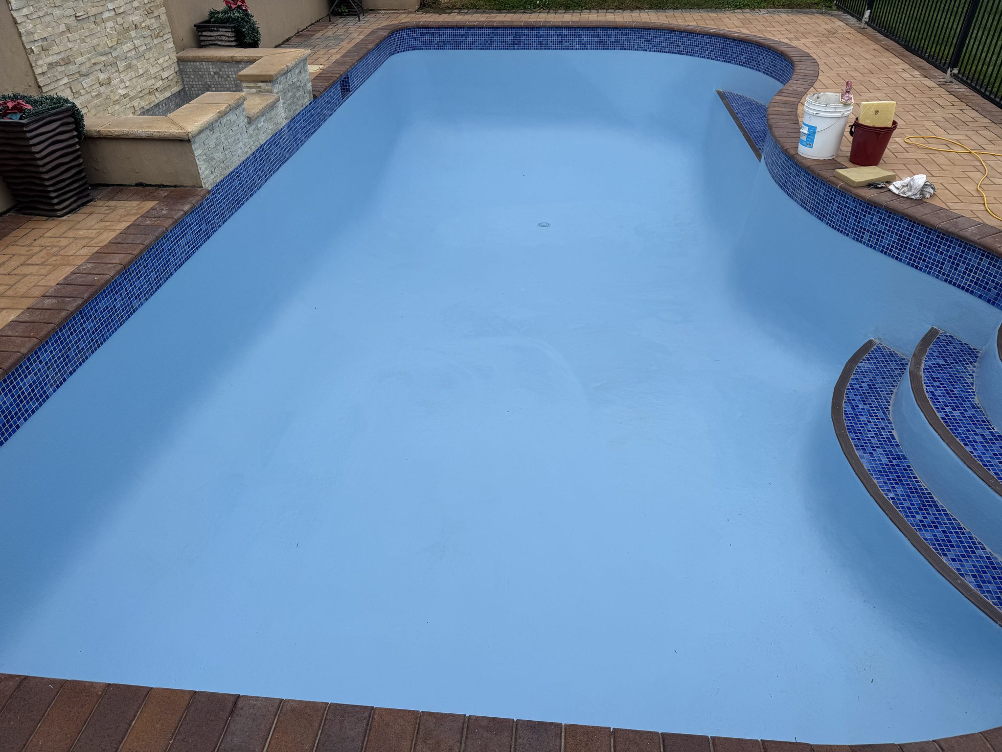 Renovated pool in bright blue with new mosaic-tiled steps
